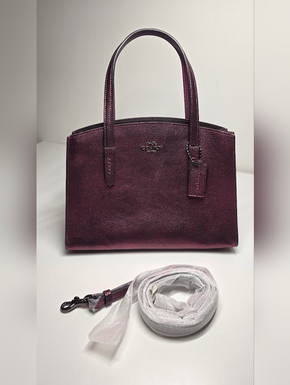 Coach Charlie Carryall in Metallic Berry Pebble leather.